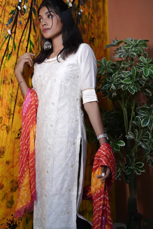 Rich white with embroidery and golden thread work Silk Kurti with bright red and yellow bandhej Dupatta.