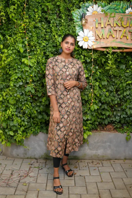 Collared rayon A-line princess cut Kurti with golden and red print work on a black base.