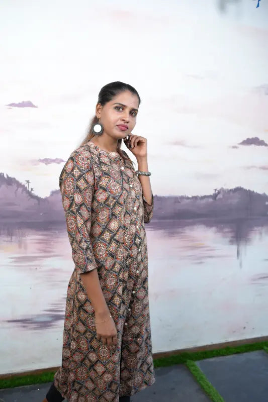 Collared rayon A-line princess cut Kurti with golden and red print work on a black base.