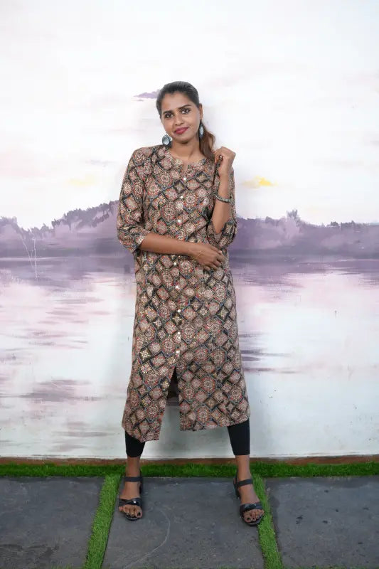 Collared rayon A-line princess cut Kurti with golden and red print work on a black base.