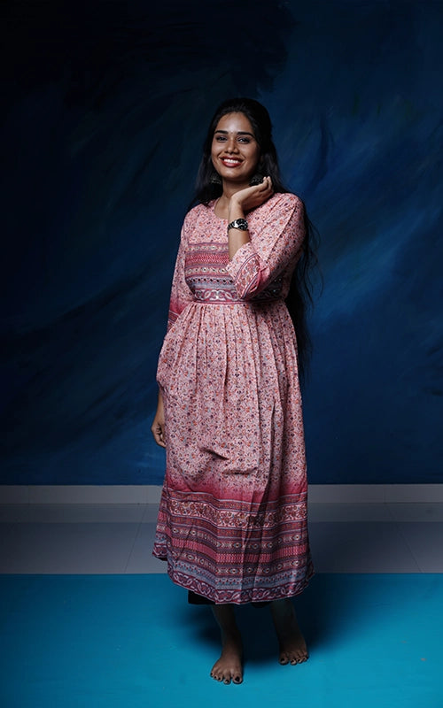 Flared salmon pink poly muslin Kurti with mirror work yoke with back tie detail.