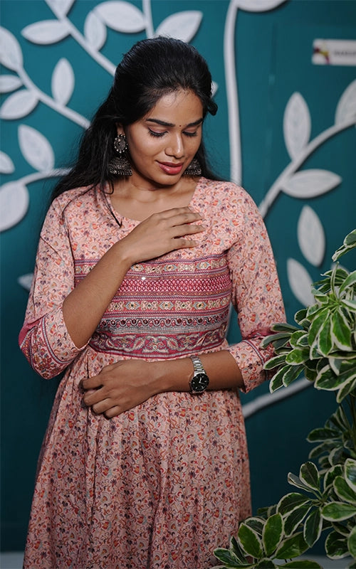 Flared salmon pink poly muslin Kurti with mirror work yoke with back tie detail.