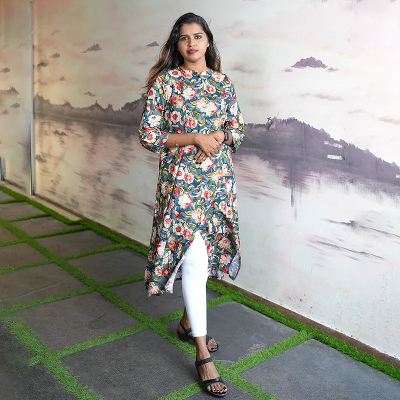 A-line princess cut rayon kurti with side pockets with floral design on a bluish green base.