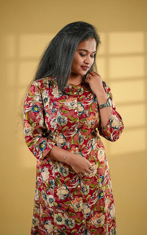 A-line princess cut rayon kurti with side pockets with floral design on a maroon base.