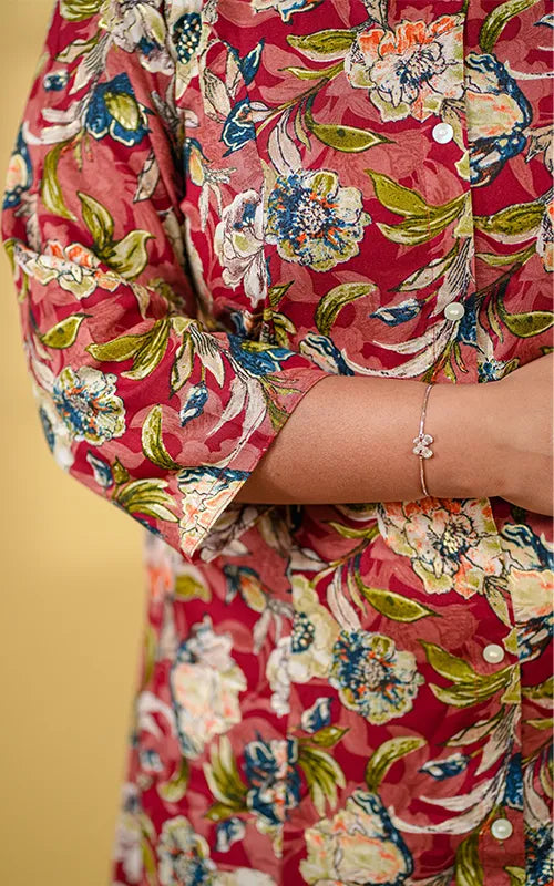 A-line princess cut rayon kurti with side pockets with floral design on a maroon base.