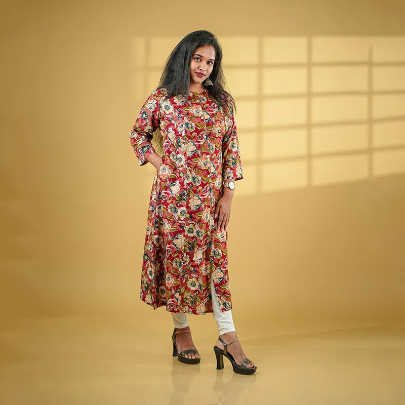 A-line princess cut rayon kurti with side pockets with floral design on a maroon base.