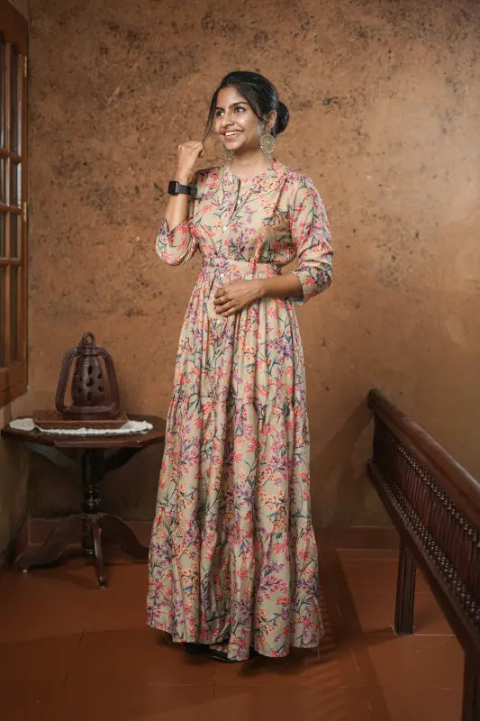Lovely flared muslin silk gown style kurti with floral design on olive green base with belt.