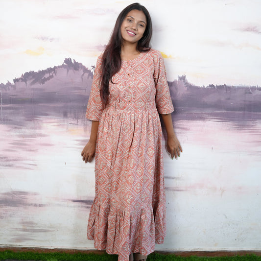 Flared cotton salmon coloured Kurti with beautiful mirror work and belt.