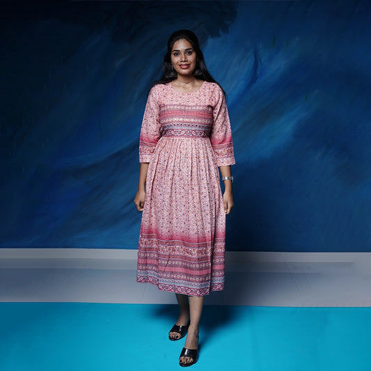 Flared salmon pink poly muslin Kurti with mirror work yoke with back tie detail.